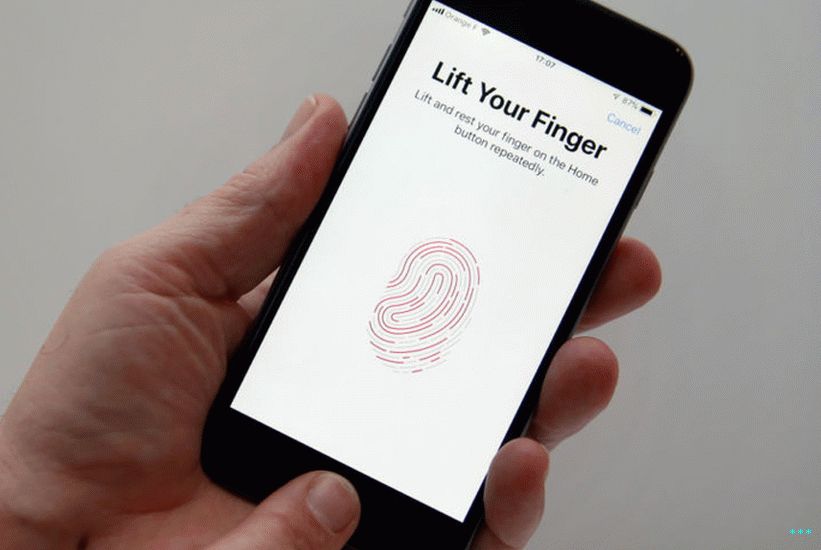 Osoba ruka držící iPhone při nastavování funkce snímače otisků prstů Touch ID.